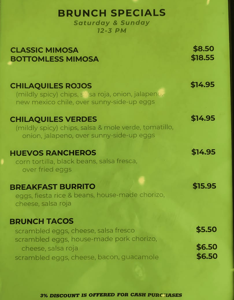 A green menu board displays brunch specials, including mimosas, chilaquiles, huevos rancheros, burritos, and tacos.